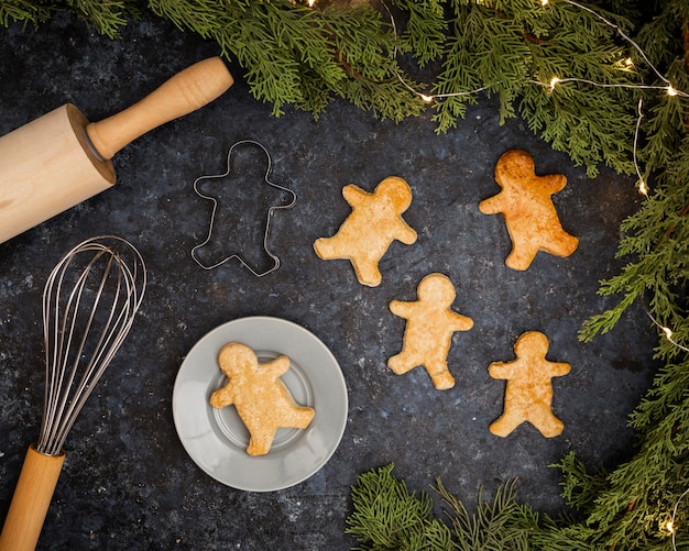 Top view arrangement with gingerbread men on stucco background