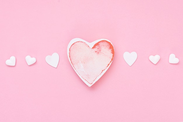 심장 모양의 쿠키와 분홍색 배경 상위 뷰 배열
