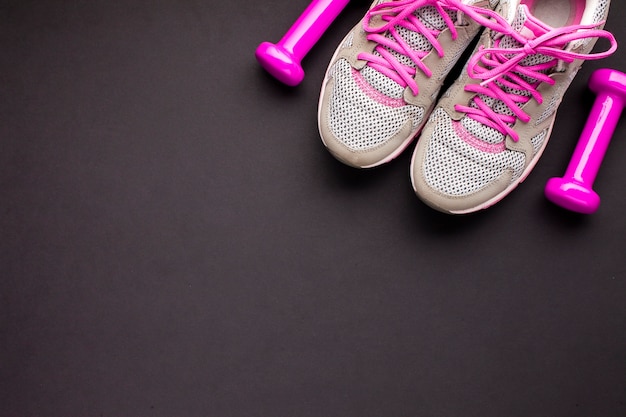 Top view arrangement with pink shoes and dumbbells