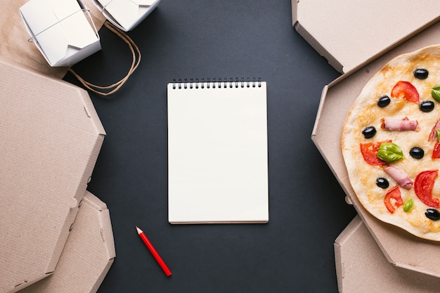 Free photo top view arrangement with pizza boxes and notebook