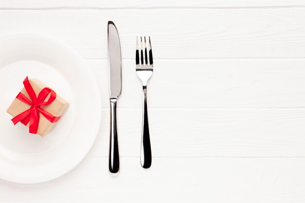 Top view arrangement with plate, cutlery and gift