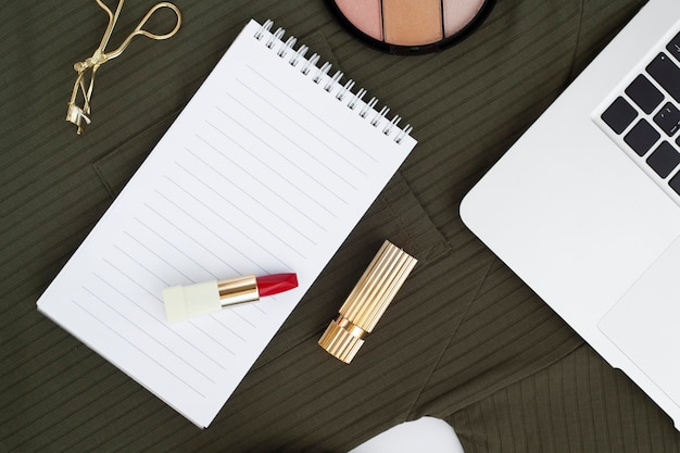 Top view arrangement with red lipstick on notebook