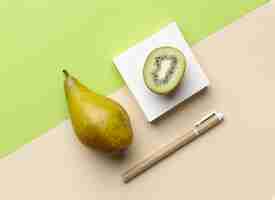Free photo top view arrangement with stationery elements and fruits