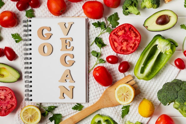 Top view arrangement with vegetables and notebook