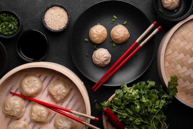 Free photo top view of asian dumplings with chopsticks and herbs
