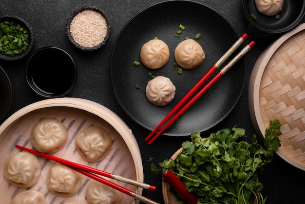 Top view of asian dumplings with chopsticks and herbs