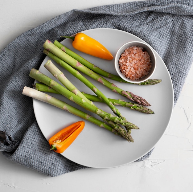 Foto gratuita vista dall'alto asparagi, pepe e sale himalayano sulla piastra con carta da cucina