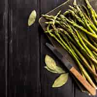 Free photo top view of asparagus with knife and bay leaves