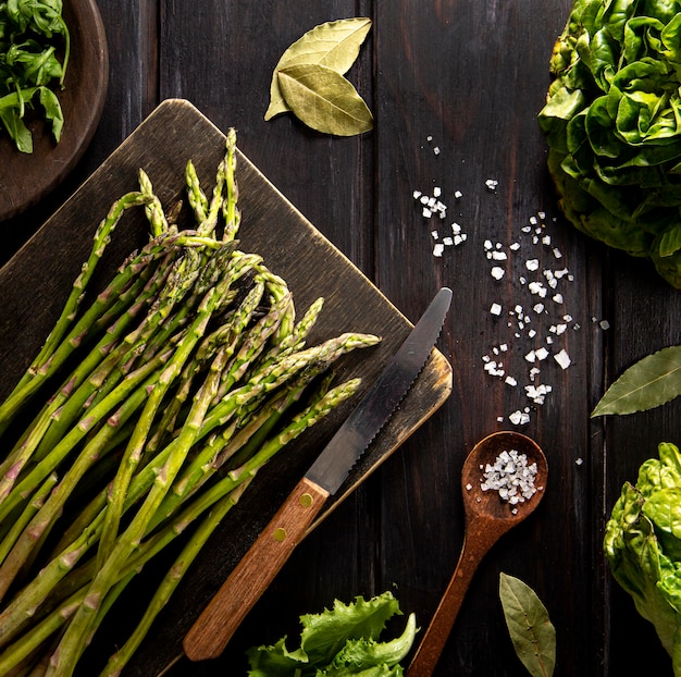 Top view of asparagus with salad and wooden spoon