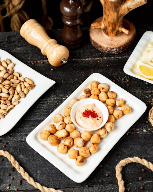 Top view of assorted beer snacks as fried dushbara on wood