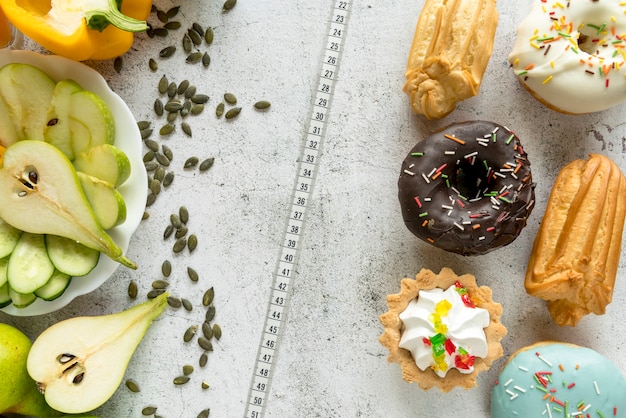 Top view of assorted sweet food; fresh fruits with vegetables and measuring tape