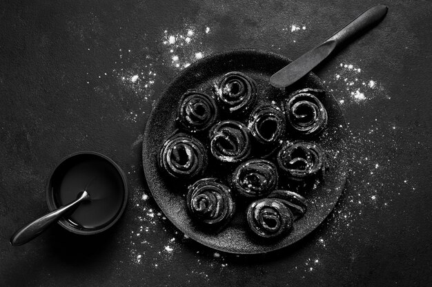 Top view assortment of black delicious food in dark plate