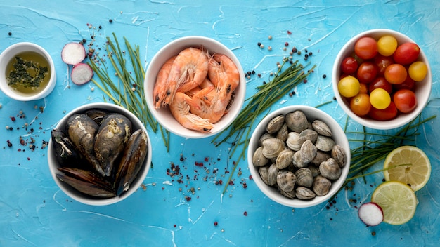 Top view of assortment of bowls with tomatoes and clams