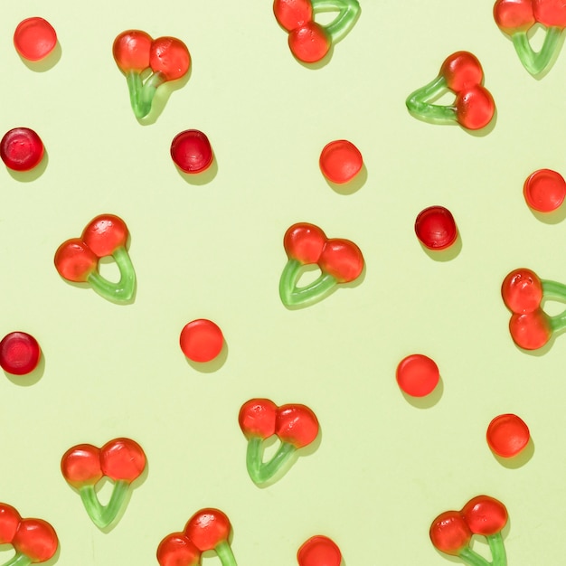 Top view assortment of colorful candies on green background