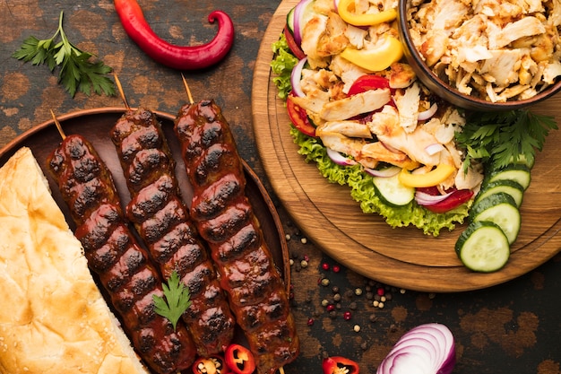 Foto gratuita vista dall'alto dell'assortimento di deliziosi kebab con verdure ed erbe aromatiche