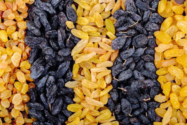 Top view of assortment of dried fruits black and yellow raisins