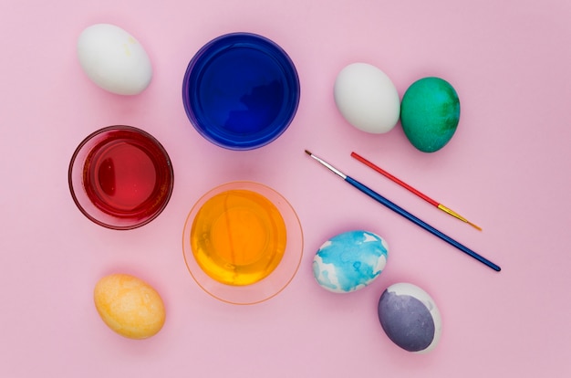 Top view of assortment of egg paint for easter with brushes