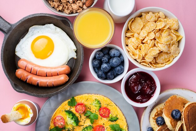 Top view of assortment of food with omelette and sausages