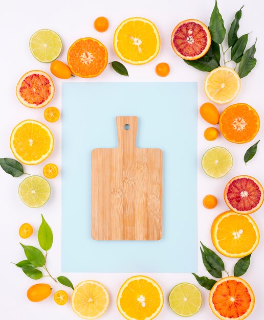 Top view assortment of fresh fruits with chopping board
