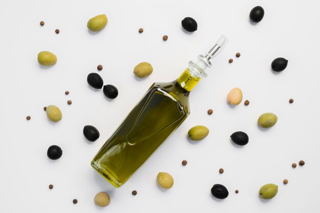 Top view assortment of olives and bottle of oil