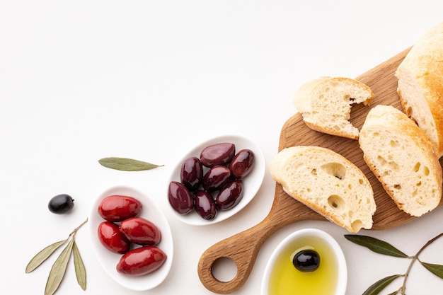 Free photo top view assortment of olives bread slices and olive oil with copy space