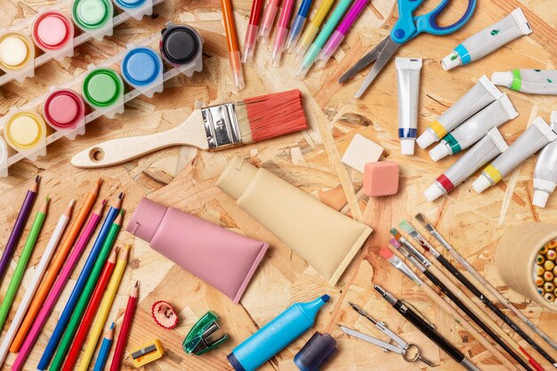 Top view assortment of paint and pencils