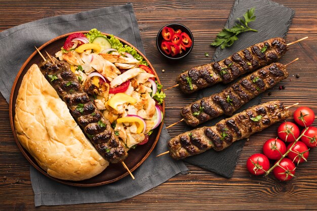 Top view of assortment of tasty kebabs with tomatoes and vegetables
