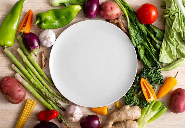Top view assortment of veggies with empty plate