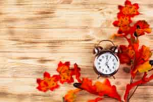 Free photo top view autumn leaves with clock