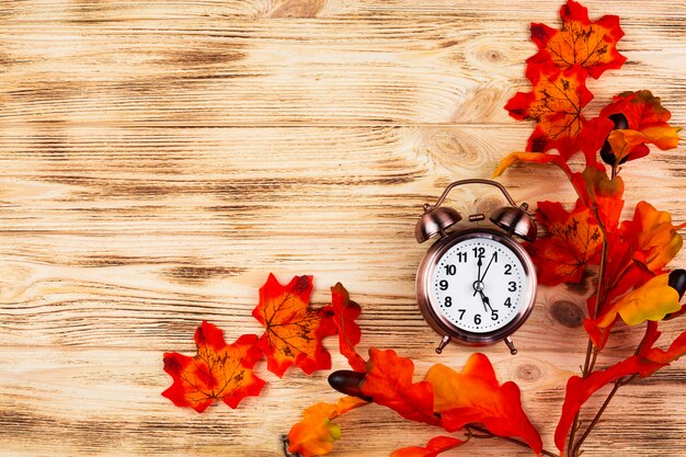 Top view autumn leaves with clock