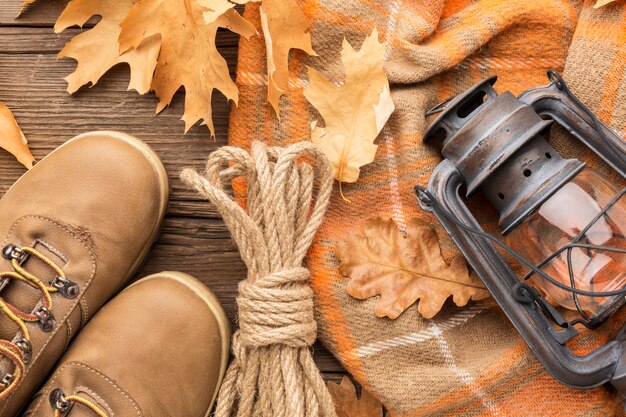 Top view of autumn leaves with lantern and boots