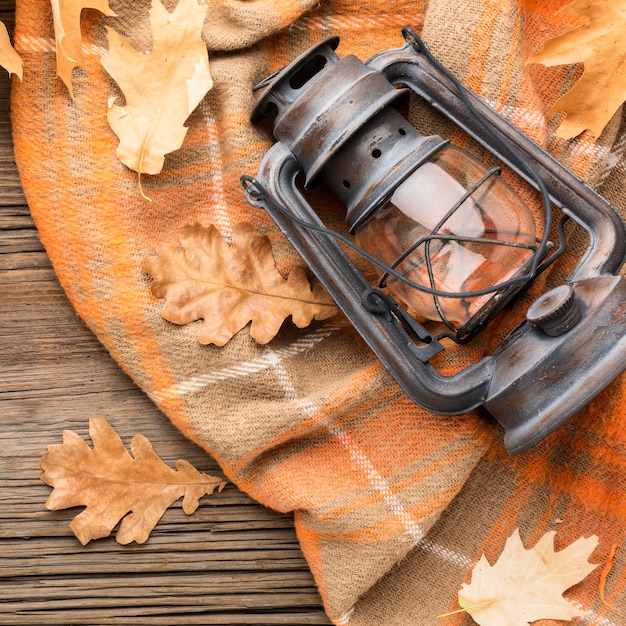 Free photo top view of autumn leaves with lantern