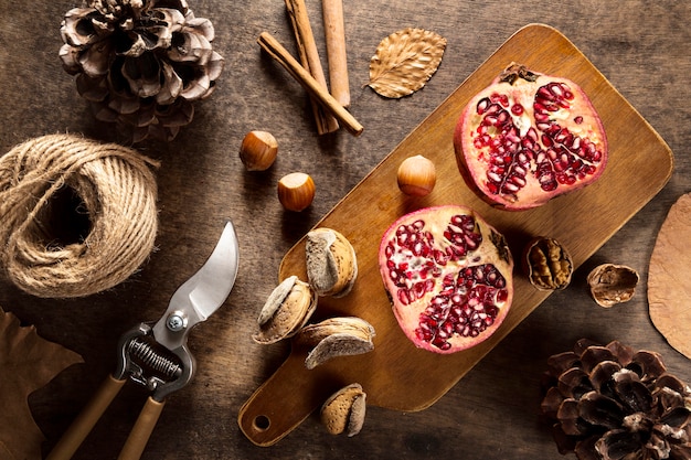 Free photo top view of autumn pomegranates with cinnamon sticks and string