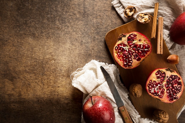 Top view of autumn pomegranates with copy space and cinnamon sticks