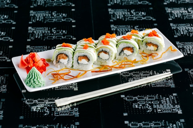 Vista dall'alto di involtini di sushi di avocado con salmone condita con tobiko rosso