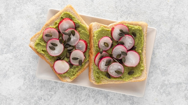 Top view avocado toast with radish and seeds on plate