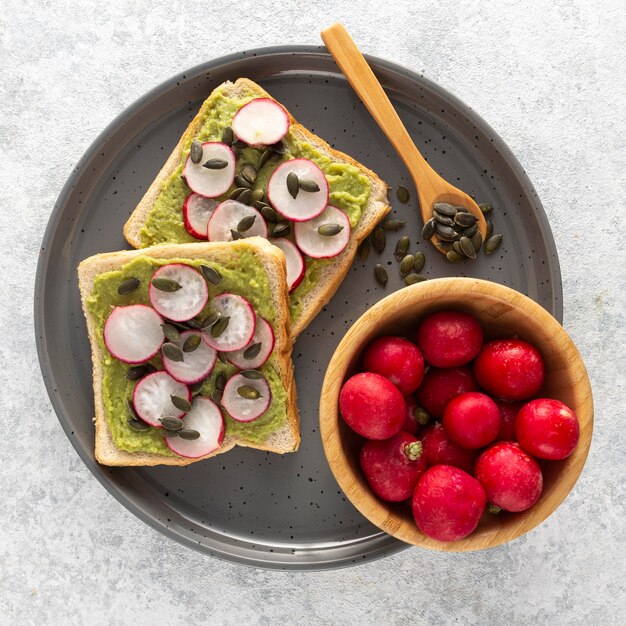 Top view avocado toast with radish and seeds on tray