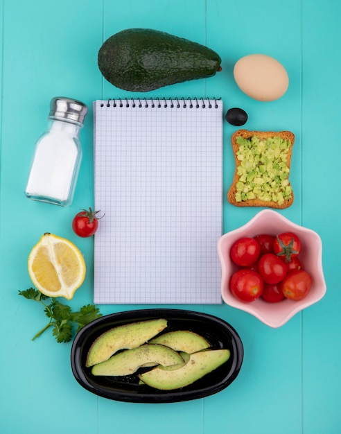 Foto gratuita vista dall'alto di avocado con uovo di oliva fetta di pane tostato con polpa di avocado limone