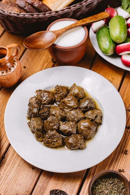 Top view of azerbaijani grape leaves dolma plate served with yogurt and salad