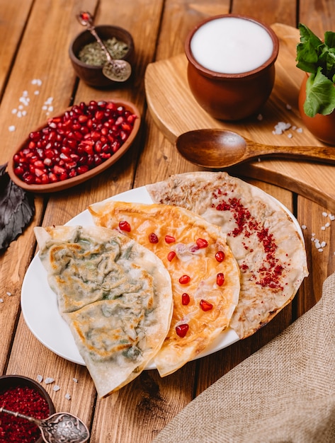 Top view of azerbaijani gutabs platter with herbs pumpkin and meat served with yogurt