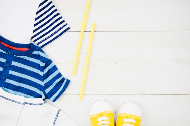 Top view baby clothes with wooden background