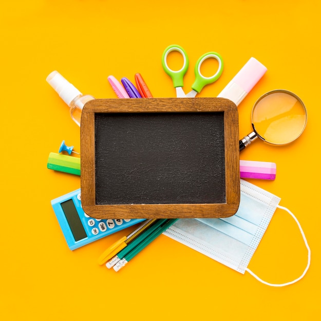 Top view of back to school essentials with blackboard and pencils