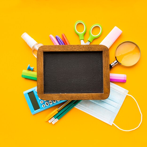 Top view of back to school essentials with blackboard and pencils