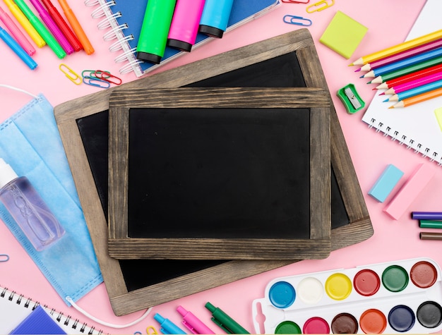 Top view of back to school essentials with blackboards and medical mask