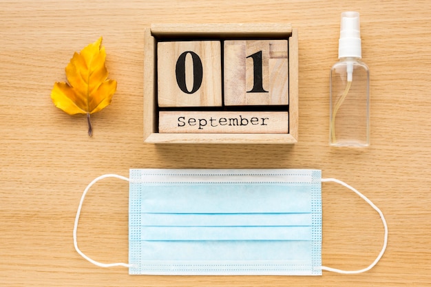 Top view of back to school essentials with medical mask and calendar