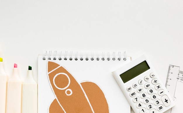 Top view of back to school essentials with notebook and calculator