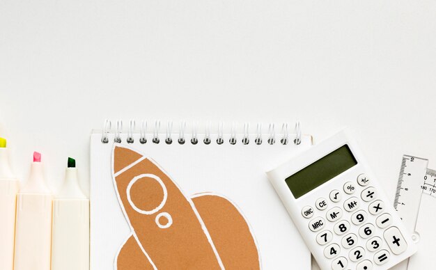 Top view of back to school essentials with notebook and calculator