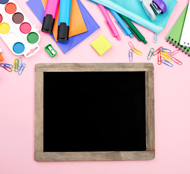 Top view of back to school essentials with pencils and blackboard