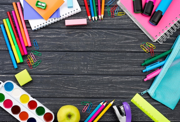 Top view of back to school stationery with apple and copy space