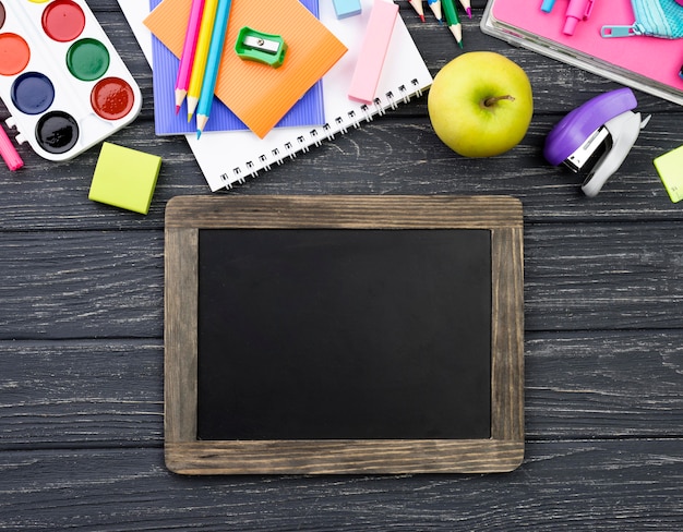 Free photo top view of back to school stationery with blackboard and apple